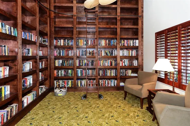 a living room with furniture and a book shelf