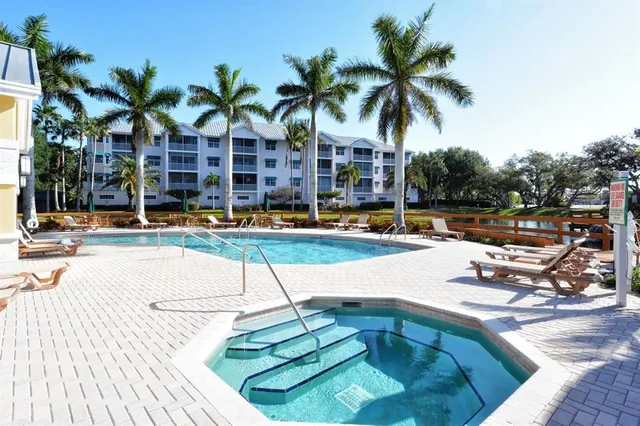 a view of a swimming pool with a lounge chair and palm trees