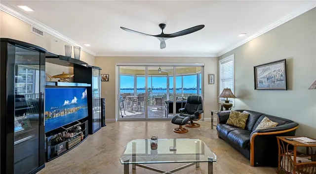 a living room with furniture a flat screen tv and a floor to ceiling window