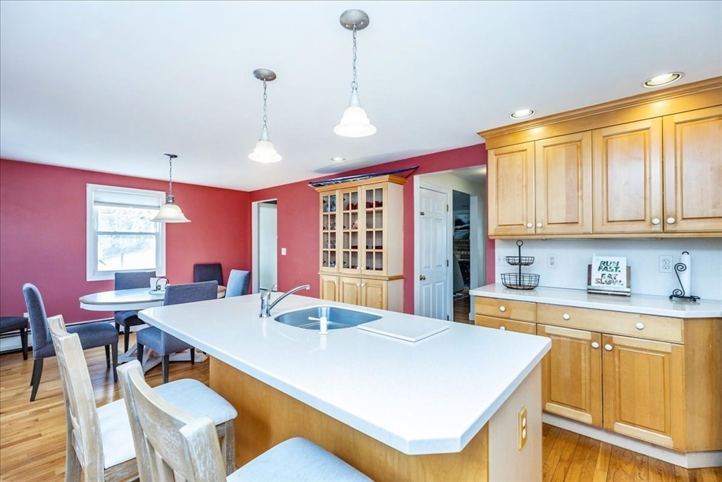52 Albemarle Avenue, Unit 52 Lexington, MA 02420 - Photo 6 of 23 a large kitchen with kitchen island a stove a sink a dining table and chairs