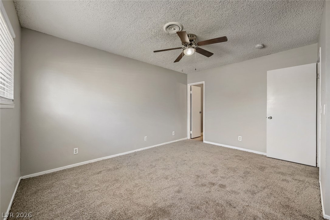 6321 Portola Road Las Vegas, NV 89108 - Photo 21 of 29 An inviting room features plush carpeting and ample natural light from the window, creating a serene environment.