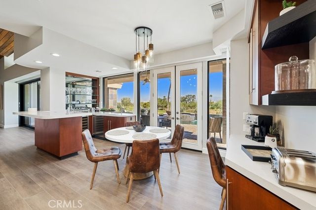 a dining room with furniture a chandelier and kitchen view