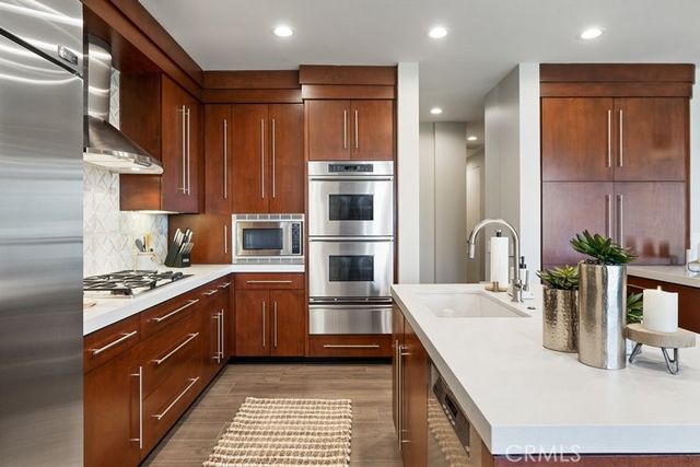 a kitchen with kitchen island a counter top space cabinets and stainless steel appliances