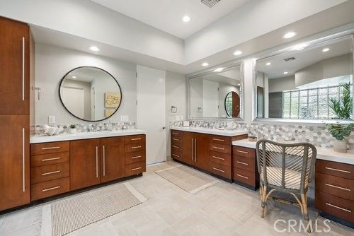 a bathroom with a granite countertop sink a mirror and a vanity