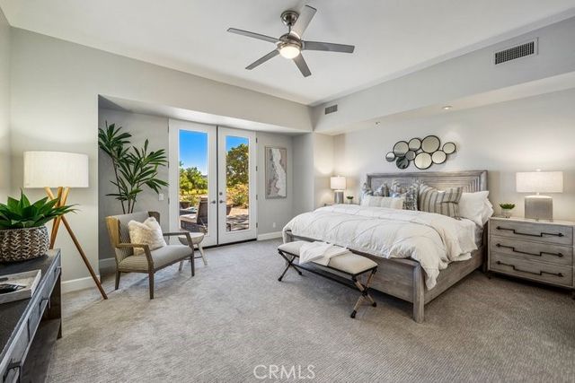 a spacious bedroom with a bed and a chandelier