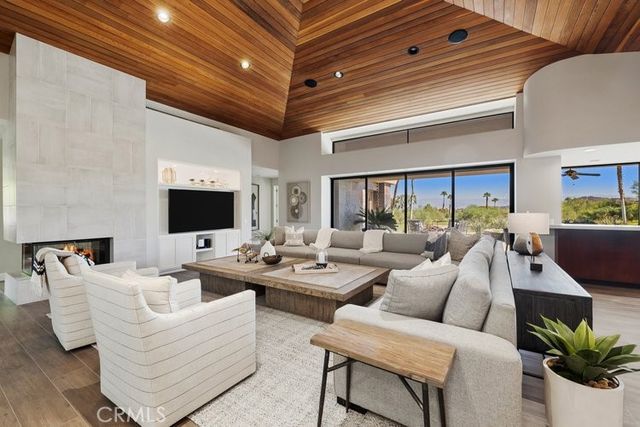 a living room with furniture kitchen view and a flat screen tv
