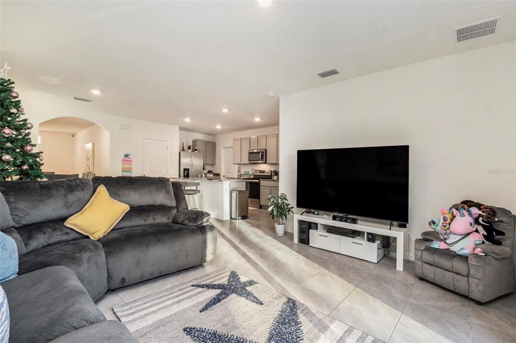 9319 Forge Breeze Loop Wesley Chapel, FL 33545 - Photo 13 of 45 a living room with furniture and a flat screen tv