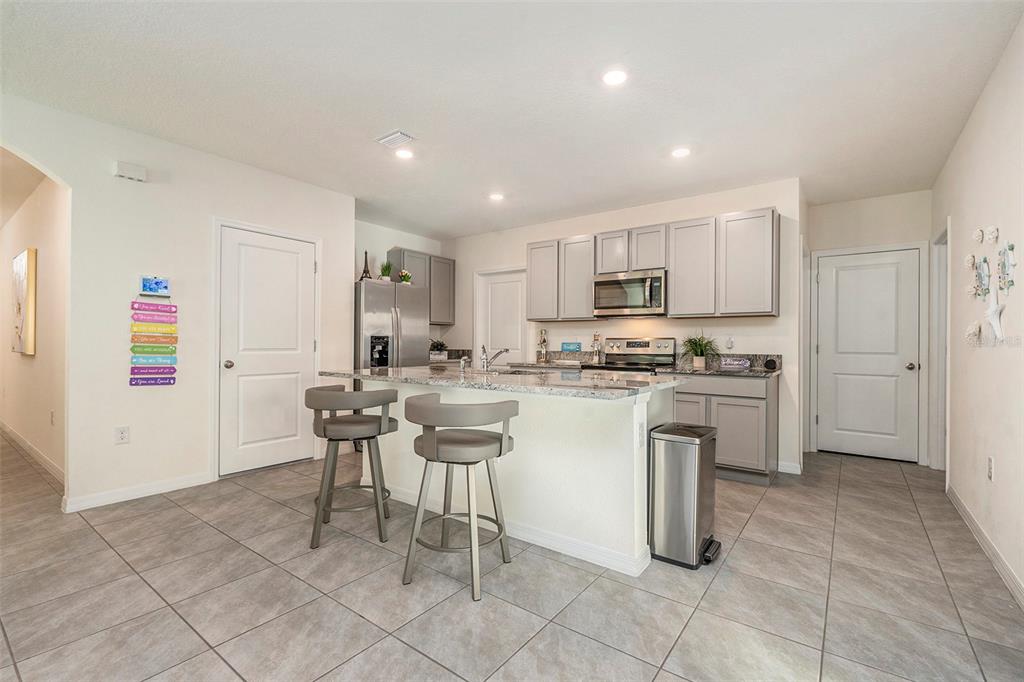 9319 Forge Breeze Loop Wesley Chapel, FL 33545 - Photo 14 of 45 a kitchen with cabinets and chairs