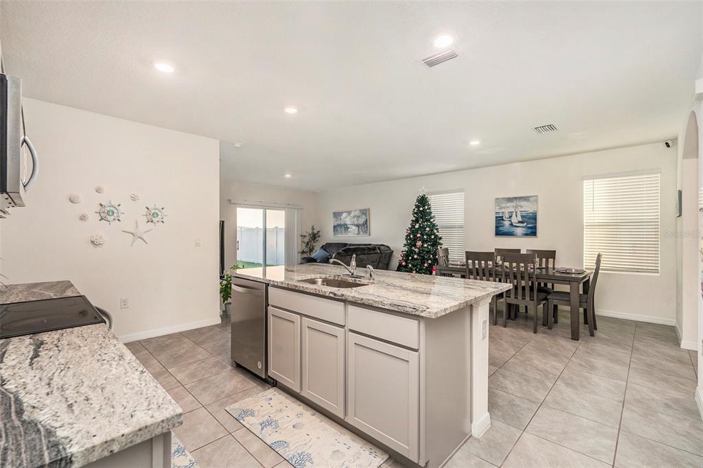 9319 Forge Breeze Loop Wesley Chapel, FL 33545 - Photo 15 of 45 a kitchen with a stove a refrigerator and a dining table