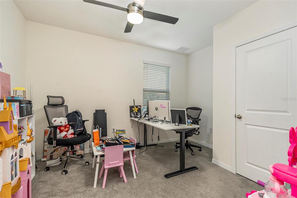 9319 Forge Breeze Loop Wesley Chapel, FL 33545 - Photo 16 of 45 a view of a workspace with furniture and a fan