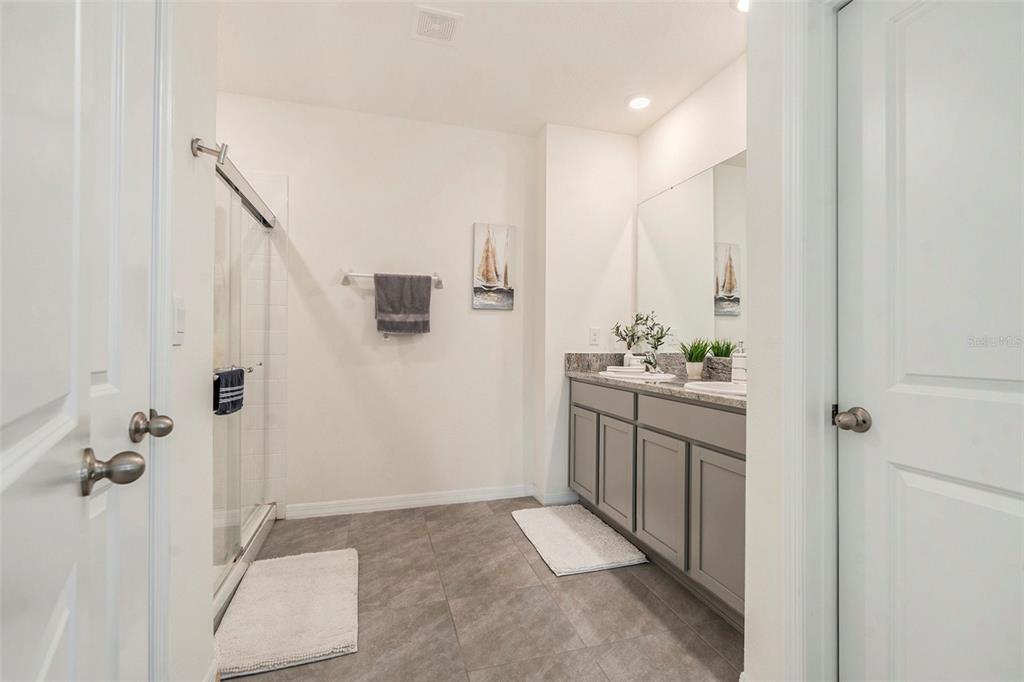 9319 Forge Breeze Loop Wesley Chapel, FL 33545 - Photo 19 of 45 a bathroom with a granite countertop sink a toilet and shower