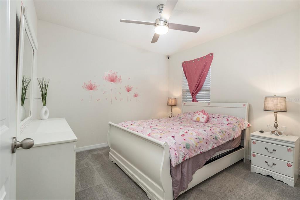 9319 Forge Breeze Loop Wesley Chapel, FL 33545 - Photo 20 of 45 a bedroom with a bed and a chandelier