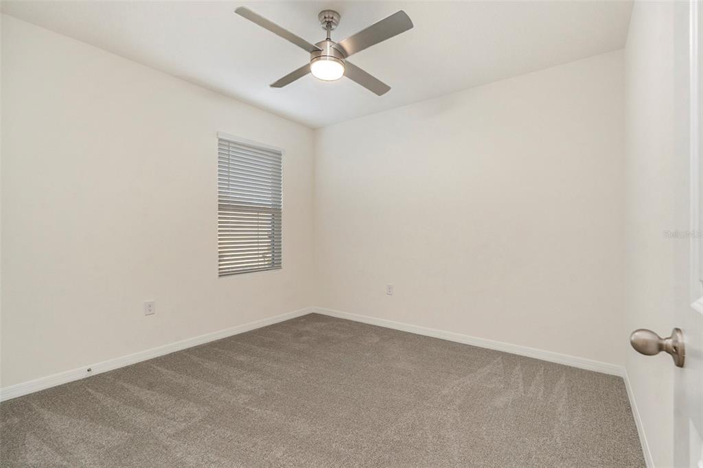 9319 Forge Breeze Loop Wesley Chapel, FL 33545 - Photo 23 of 45 an empty room with a window and a fan