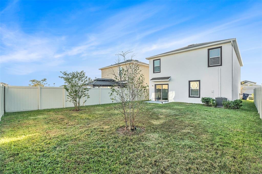 9319 Forge Breeze Loop Wesley Chapel, FL 33545 - Photo 26 of 45 a view of a big house with a yard and large tree