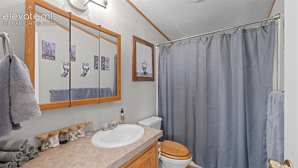33975 Highway 94 Yoder, CO 80864 - Photo 18 of 40 Bathroom featuring a wood-framed medicine cabinet, vanity with integrated sink, laminate countertop, and a shower/tub combination with a shower rod