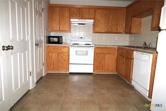 a kitchen with a stove top oven sink and cabinets