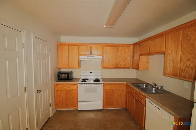 a kitchen with a sink stove and cabinets