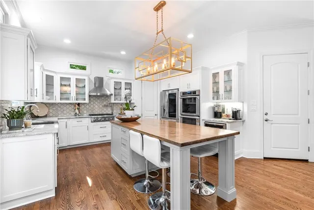 a kitchen with stainless steel appliances granite countertop a refrigerator and a sink