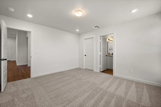 an empty room with closet and a bathroom