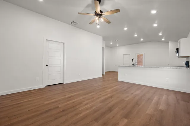 a view of an empty room with a kitchen