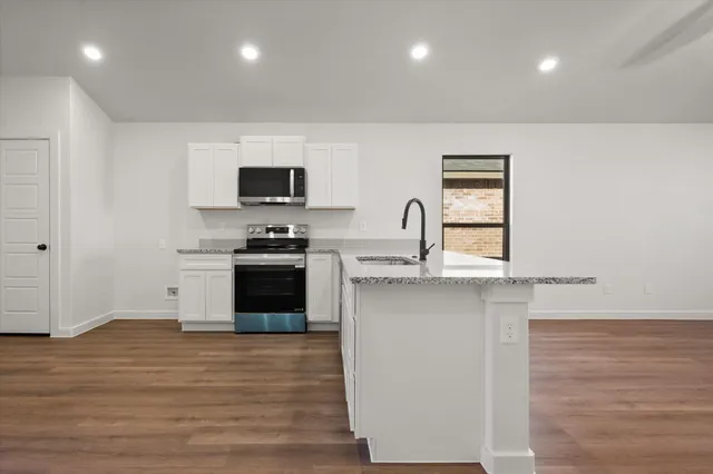 a kitchen with a sink and a stove top oven