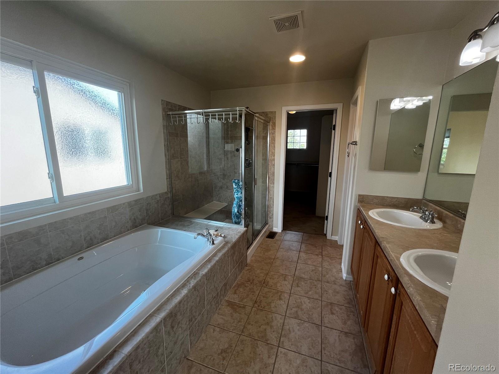 8121 Raspberry Drive Frederick, CO 80504 - Photo 16 of 27 a bathroom with a tub sink and mirror
