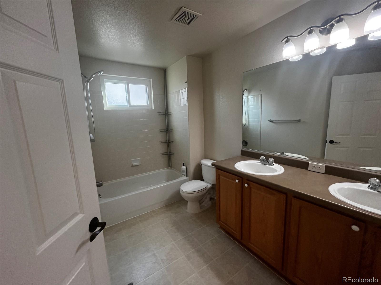 8121 Raspberry Drive Frederick, CO 80504 - Photo 20 of 27 a bathroom with a granite countertop sink toilet mirror and bathtub