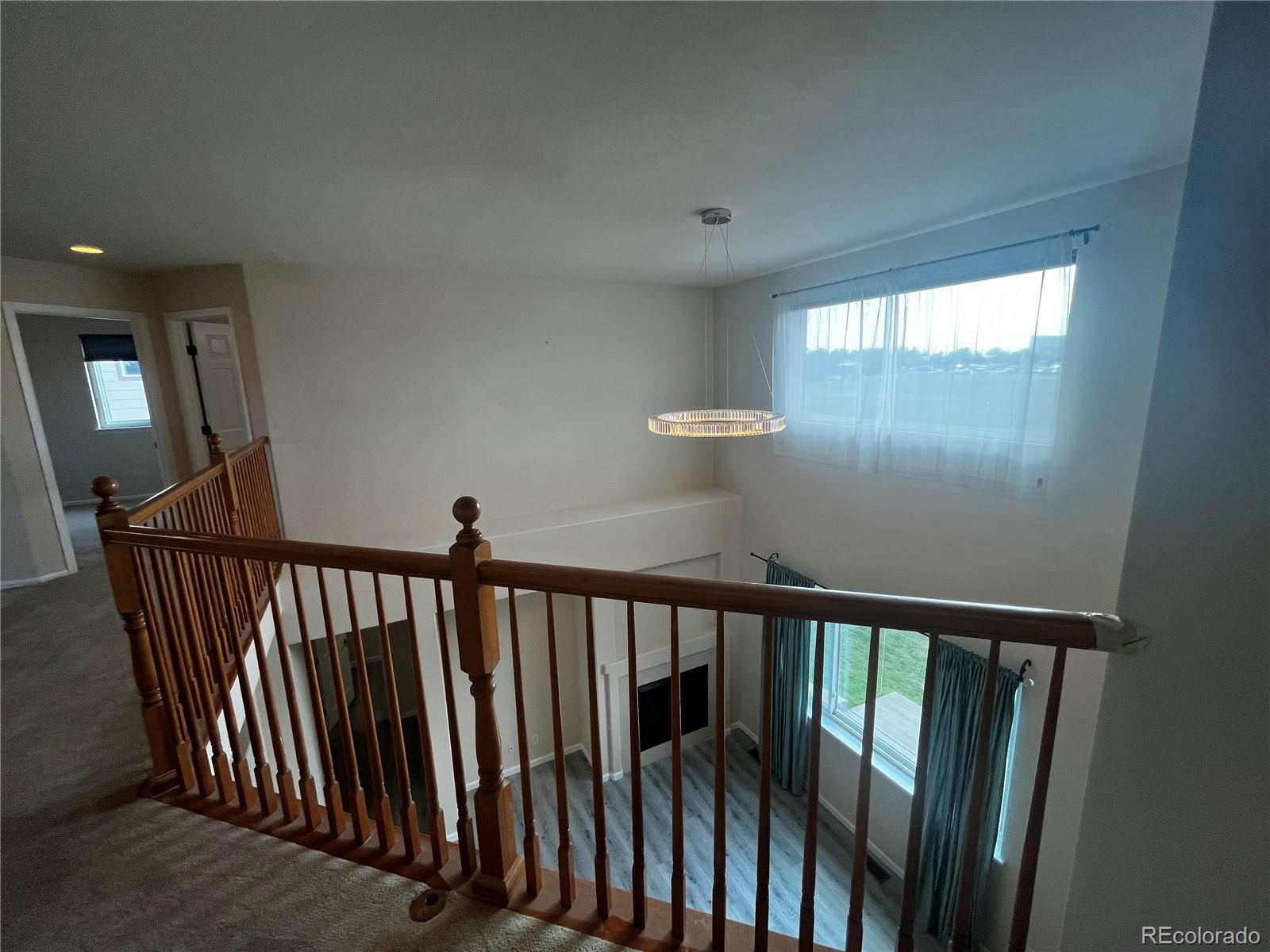 8121 Raspberry Drive Frederick, CO 80504 - Photo 21 of 27 a view of a hallway with wooden floor and stairs