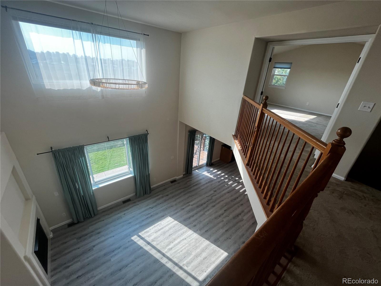8121 Raspberry Drive Frederick, CO 80504 - Photo 22 of 27 a view of an empty room with wooden floor and a window