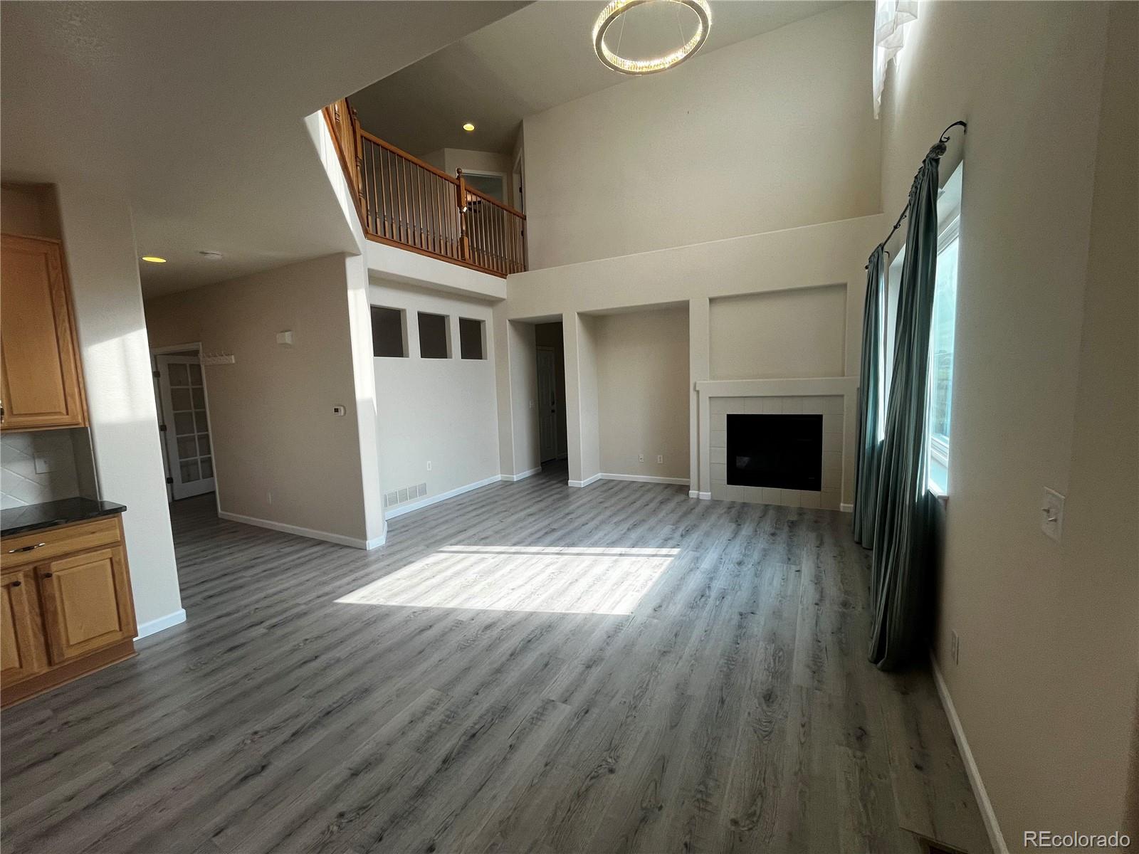 8121 Raspberry Drive Frederick, CO 80504 - Photo 7 of 27 a view of an empty room with wooden floor fireplace and a window