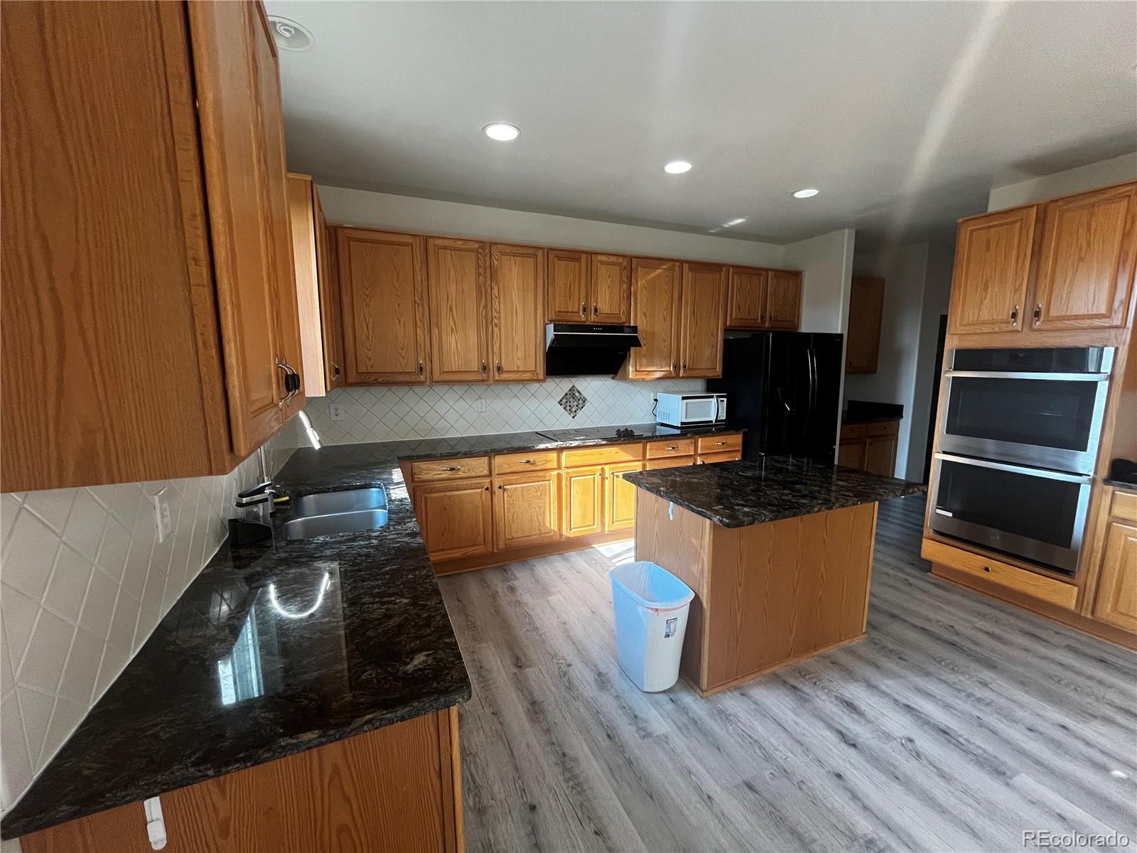 8121 Raspberry Drive Frederick, CO 80504 - Photo 8 of 27 a kitchen with stainless steel appliances granite countertop a stove a sink and a refrigerator