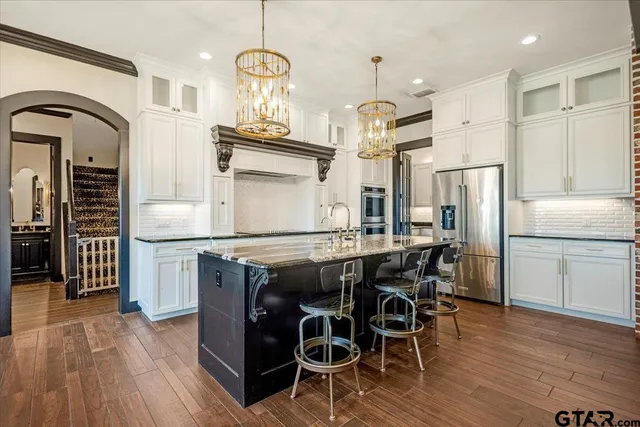 a kitchen with stainless steel appliances granite countertop a sink and stove