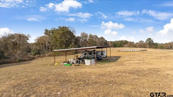 a view of a dry yard with wooden fence
