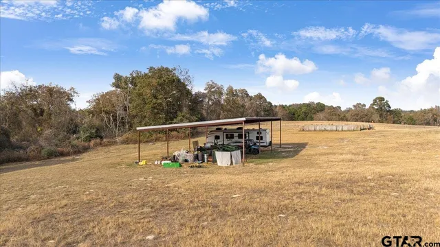 a view of a dry yard with wooden fence