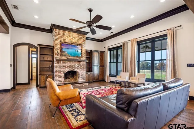 a kitchen with stainless steel appliances granite countertop a stove top oven a refrigerator a dining table and chairs with wooden floor