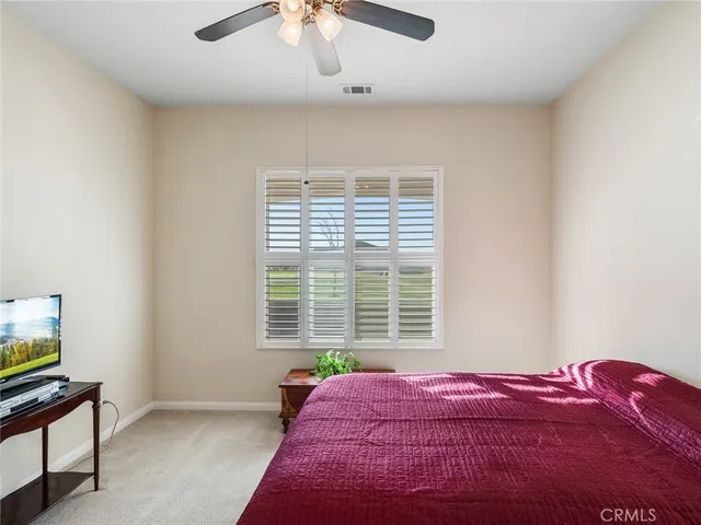 an empty room with a window and a fan