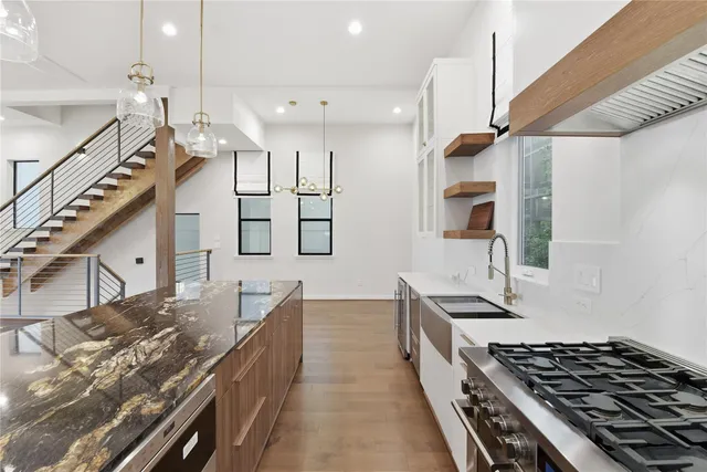 a kitchen with stainless steel appliances granite countertop a stove a sink and a refrigerator