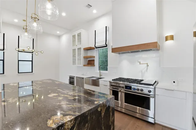 a open kitchen with stainless steel appliances granite countertop a stove and a refrigerator