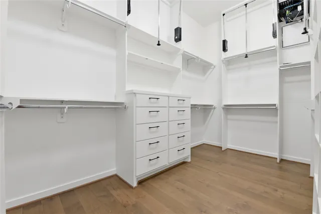 a view of a hallway with wooden floor and cabinet