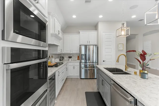 a kitchen with stainless steel appliances granite countertop a sink and a microwave