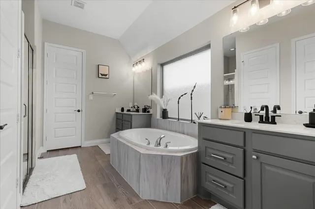 a bathroom with a tub sink and mirror
