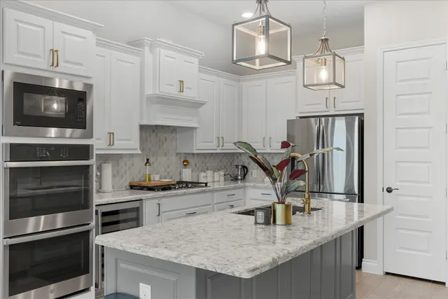 a kitchen with stainless steel appliances granite countertop a sink stove and refrigerator