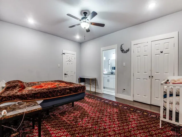 a room with chandelier fan and wooden floor