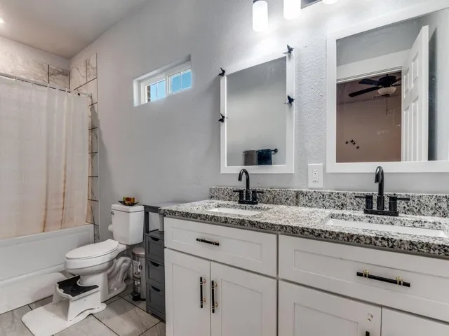 a bathroom with a granite countertop toilet sink and a mirror