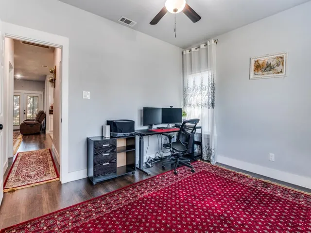 a view of a workspace with furniture and a window