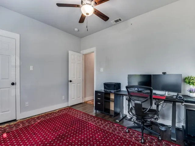 a view of a workspace with furniture and a ceiling fan