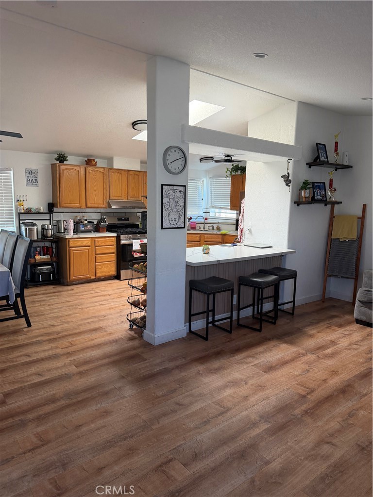 12700 Elliott, Unit 98 El Monte, CA 91732 - Photo 20 of 43 a room with stainless steel appliances kitchen island granite countertop furniture and a wooden floors