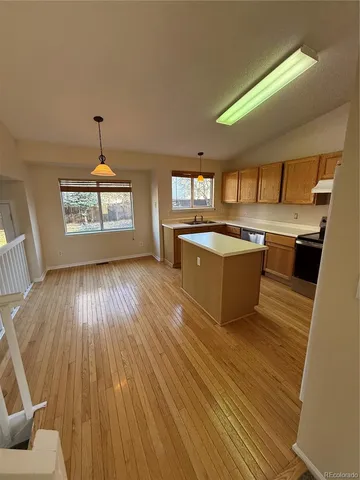 a living room with stainless steel appliances granite countertop a kitchen island wooden floors and granite top