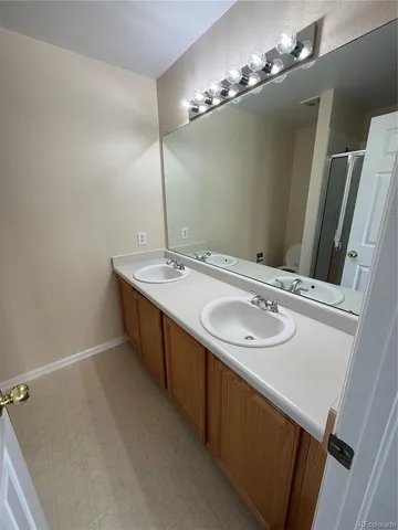 a bathroom with a double vanity sink and a mirror