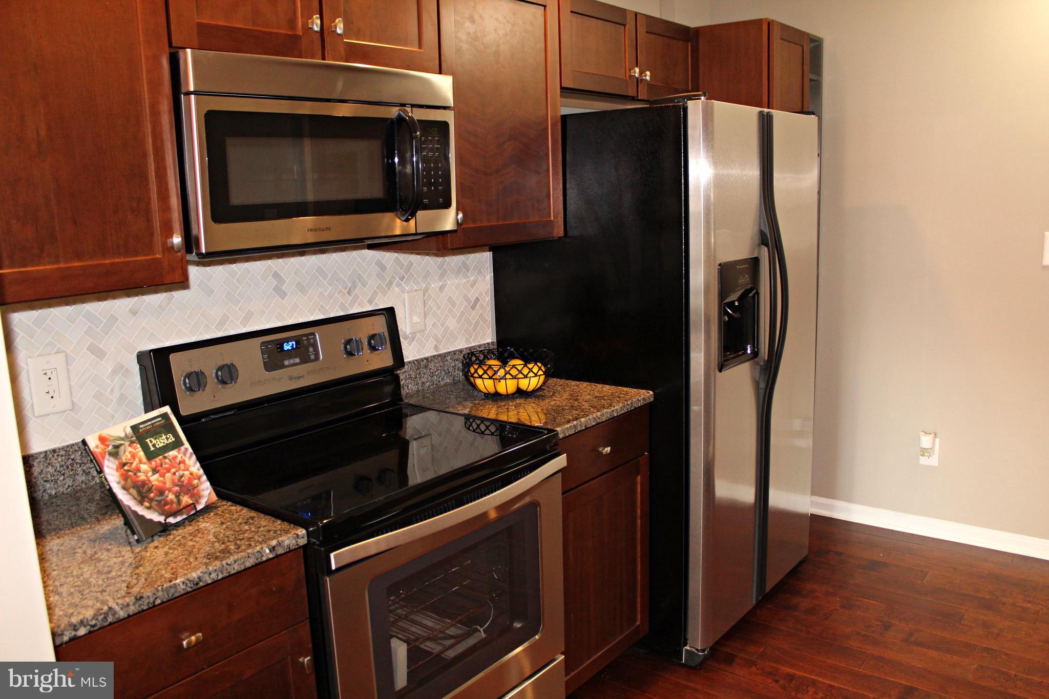 7815 Meath Road Baltimore, MD 21222 - Photo 3 of 17 a kitchen with stainless steel appliances granite countertop a stove microwave and refrigerator